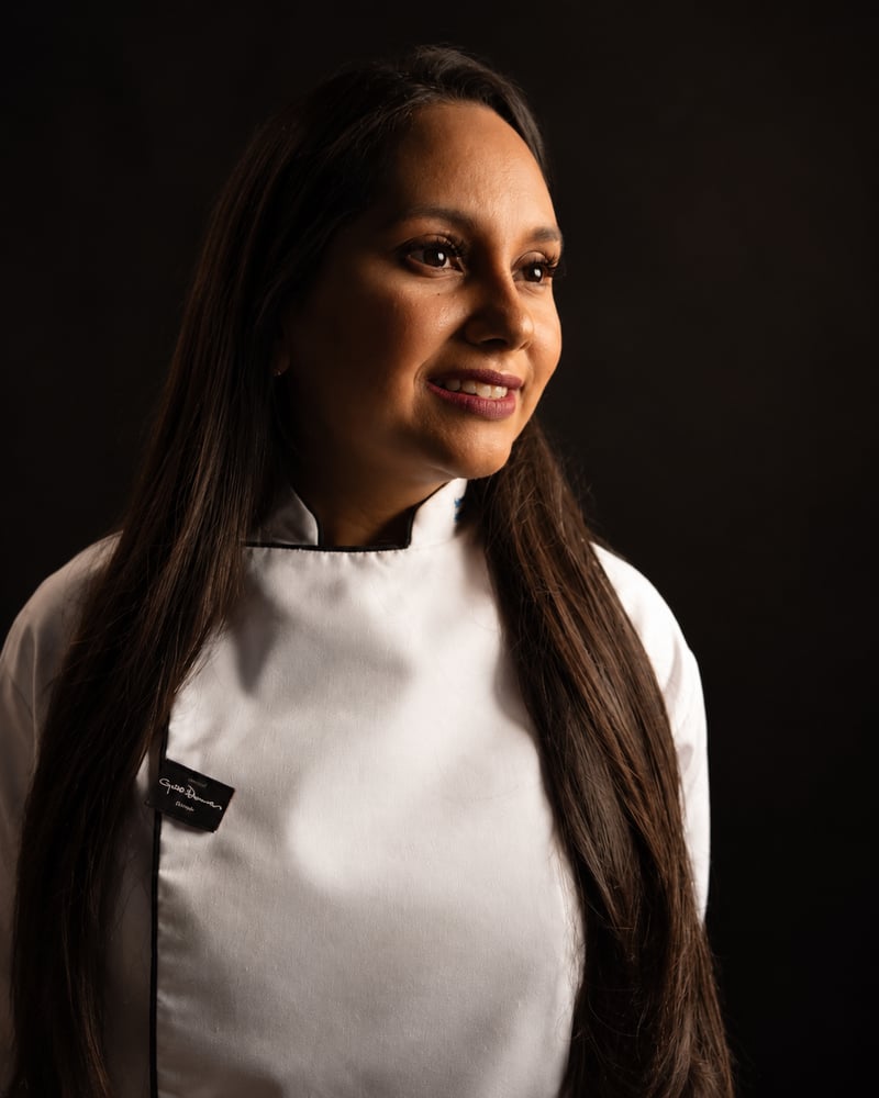 Keila Torres, sonriendo con su uniforme de cocina.