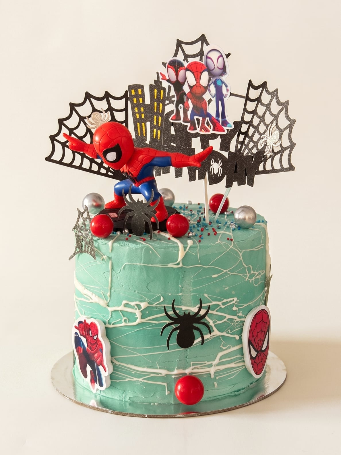 Torta verde menta de Spider-Man con telarañas blancas, arañas negras, figuras y esferas rojas y plateadas.